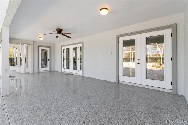 empty room with ceiling fan, speckled floor, and french doors