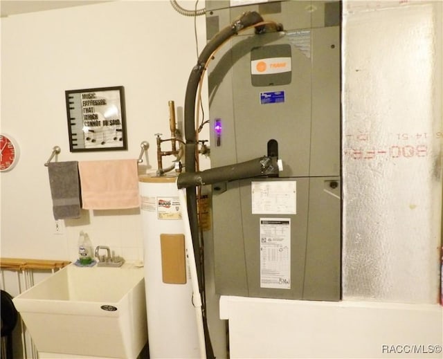 utility room featuring sink and water heater