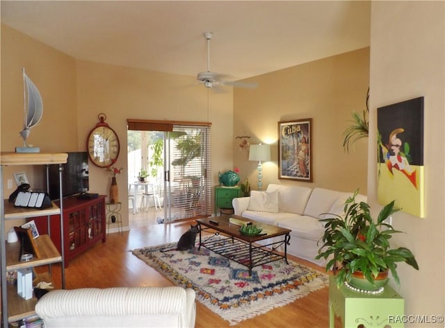 living room featuring wood-type flooring and ceiling fan