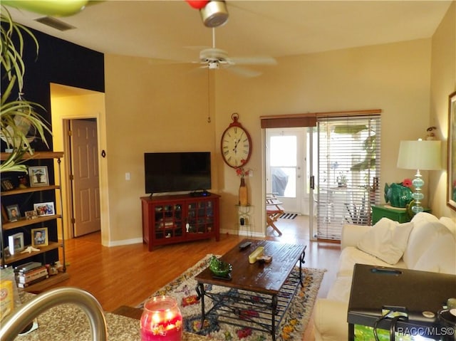 living room with ceiling fan and light hardwood / wood-style flooring