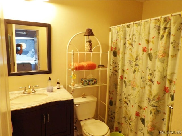 bathroom featuring vanity, toilet, and a shower with shower curtain