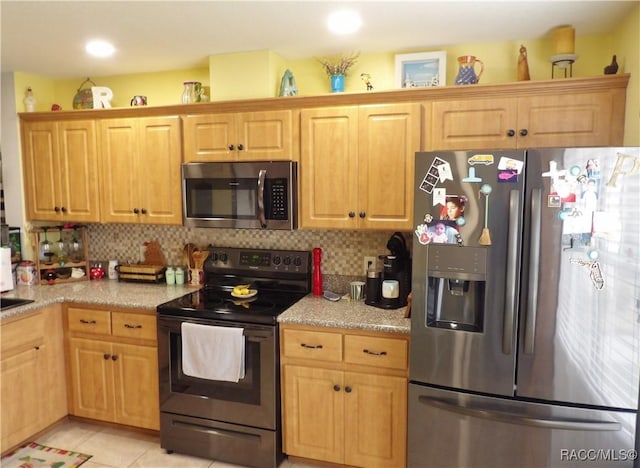 kitchen with stainless steel appliances, light tile patterned flooring, and backsplash