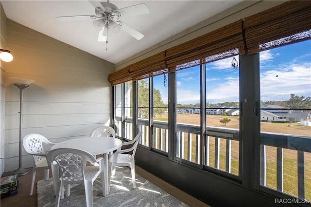 sunroom / solarium featuring lofted ceiling and ceiling fan