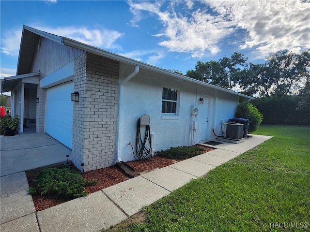 3526 N Tamarisk Ave, Beverly Hills, FL 34465 - view of side of property featuring a garage, a yard, brick siding, and stucco siding