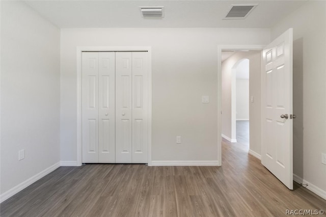 unfurnished bedroom featuring a closet and wood-type flooring