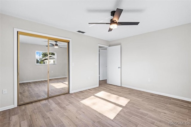 unfurnished bedroom with light hardwood / wood-style flooring, a closet, and ceiling fan