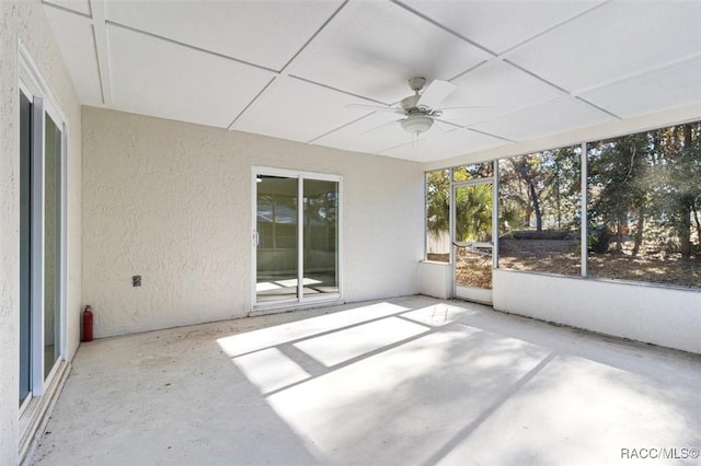 unfurnished sunroom featuring ceiling fan