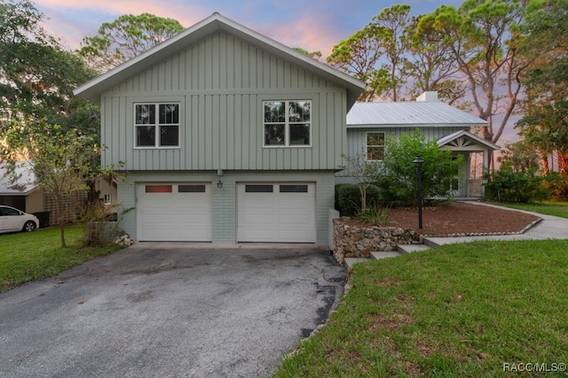 split level home with a yard and a garage