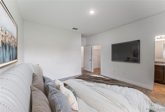 bedroom with connected bathroom and a walk in closet