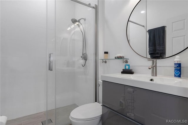 bathroom with walk in shower, vanity, and toilet