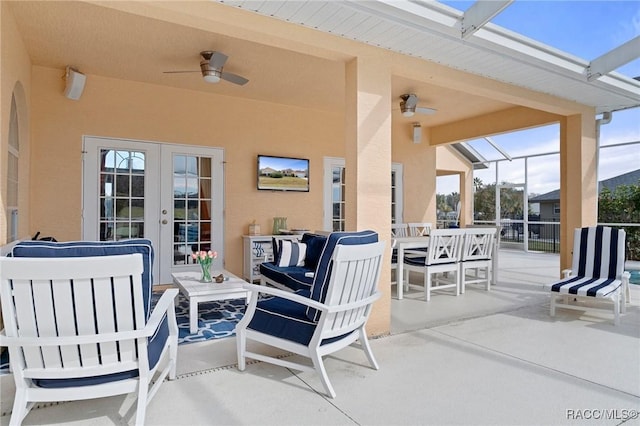 view of patio / terrace featuring glass enclosure, ceiling fan, and outdoor lounge area