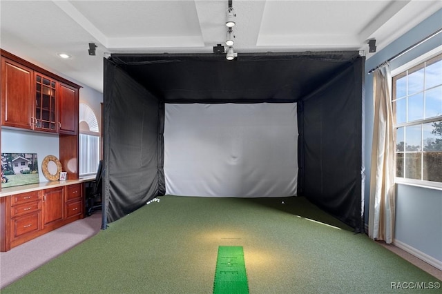 recreation room with light carpet, golf simulator, a raised ceiling, and baseboards