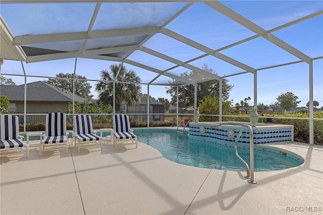 view of swimming pool featuring a lanai, a jacuzzi, and a patio area