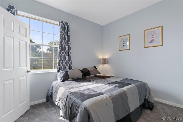 carpeted bedroom featuring multiple windows and baseboards