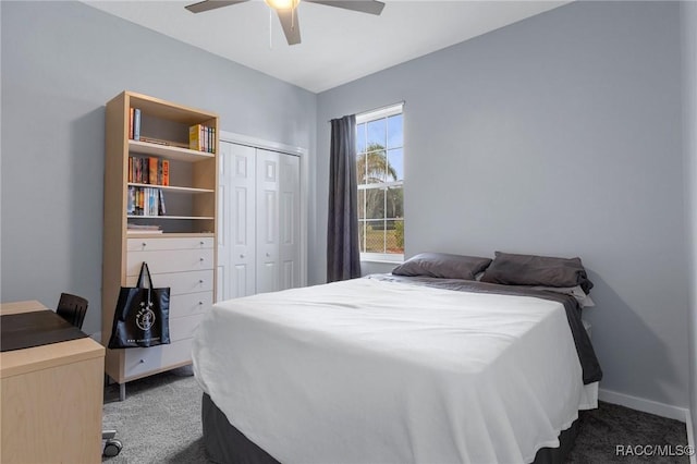 bedroom with ceiling fan, baseboards, dark colored carpet, and a closet