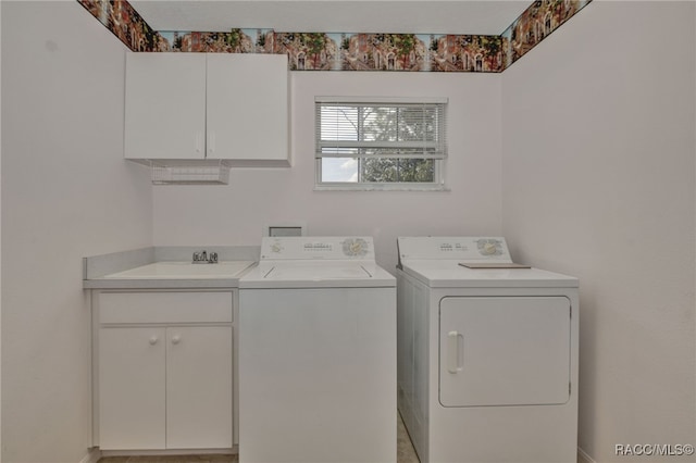 clothes washing area with cabinets, washer and dryer, and sink