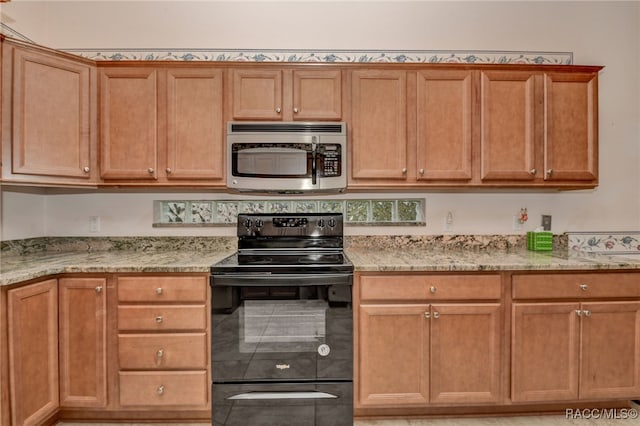 kitchen with light stone counters and black range with electric stovetop