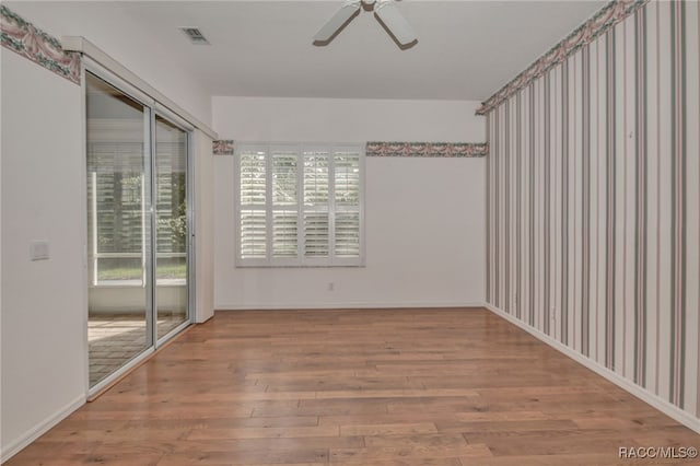 empty room with ceiling fan and hardwood / wood-style flooring