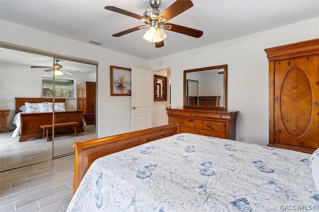 bedroom with ceiling fan, light hardwood / wood-style floors, and a closet