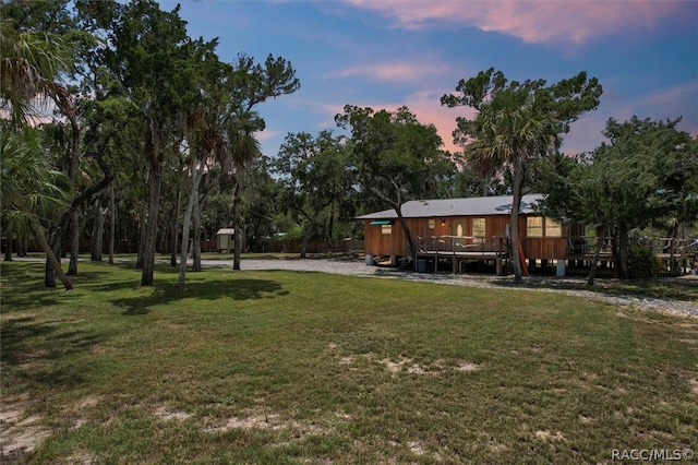 yard at dusk featuring a wooden deck