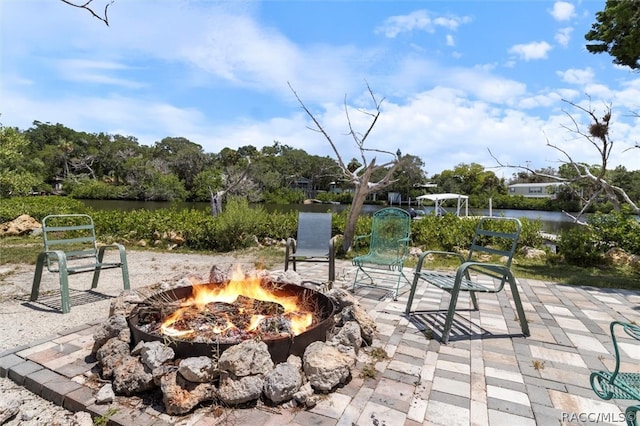 view of patio / terrace with a water view and a fire pit