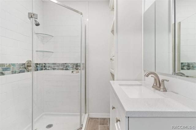 bathroom featuring wood-type flooring, vanity, and a shower with door