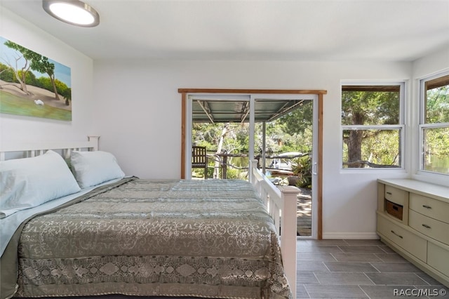 bedroom with access to exterior and dark hardwood / wood-style floors