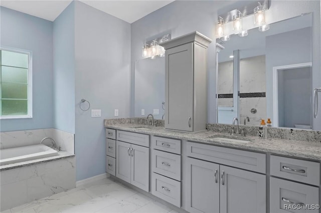 full bathroom featuring a sink, tiled shower, marble finish floor, and double vanity