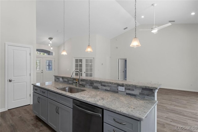 kitchen with a sink, gray cabinetry, french doors, stainless steel dishwasher, and a kitchen island with sink