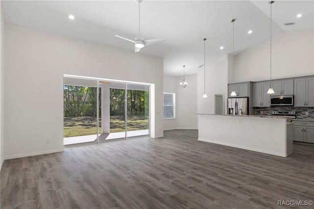 kitchen with gray cabinetry, open floor plan, high vaulted ceiling, decorative backsplash, and stainless steel appliances