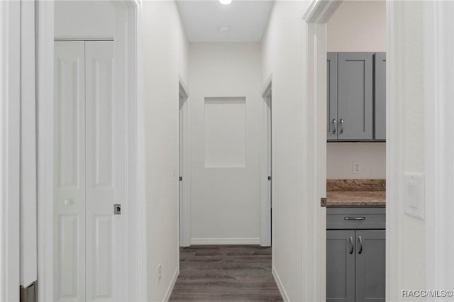 hall featuring baseboards and dark wood-style floors