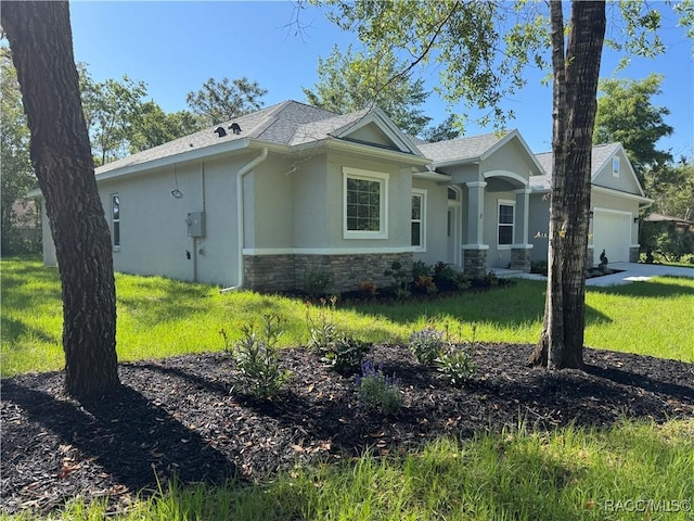 view of front of house featuring an attached garage, stucco siding, stone siding, and a front yard