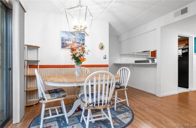 2400 Forest Dr Unit 103, Inverness, FL 34453 - dining area with wood finished floors, a chandelier, and baseboards