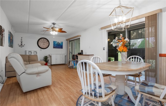 dining room featuring ceiling fan with notable chandelier and light wood-type flooring