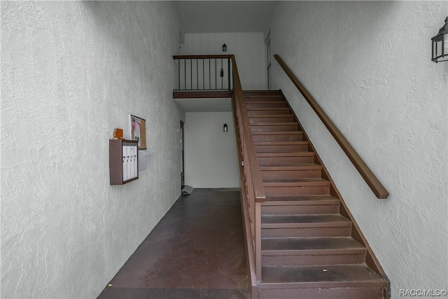 staircase featuring concrete floors