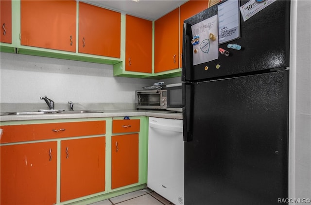 kitchen with light tile patterned flooring, white dishwasher, black fridge, and sink