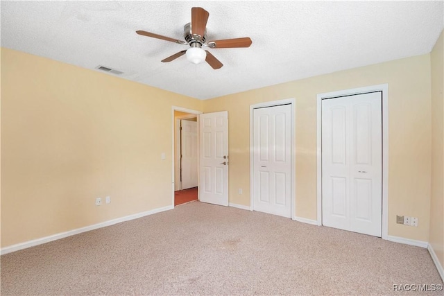 3231 S Eagle Pt, Inverness, FL 34450 - unfurnished bedroom with multiple closets, carpet, a ceiling fan, and a textured ceiling