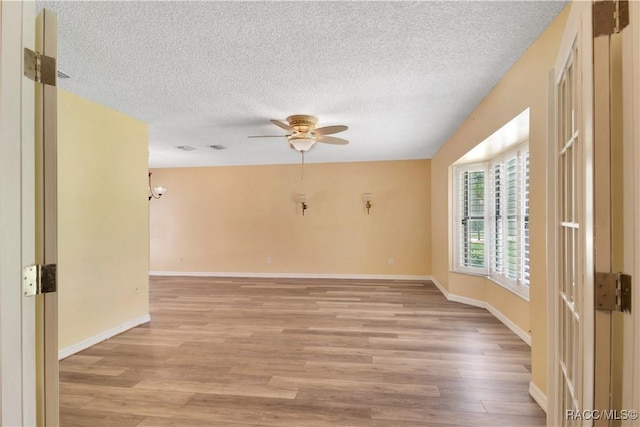 3231 S Eagle Pt, Inverness, FL 34450 - spare room featuring light wood finished floors, a textured ceiling, ceiling fan, and a chandelier