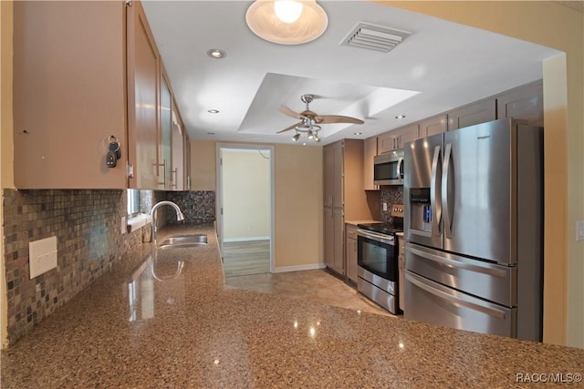 3231 S Eagle Pt, Inverness, FL 34450 - kitchen featuring stainless steel appliances, backsplash, a tray ceiling, light stone counters, and a ceiling fan