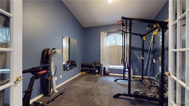 exercise room featuring a textured ceiling and lofted ceiling