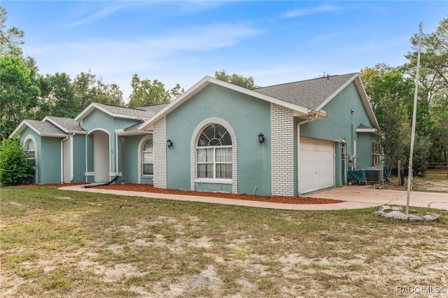 ranch-style home featuring a front lawn, central AC unit, and a garage