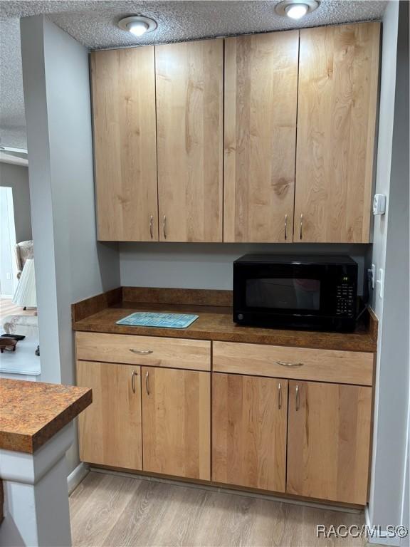 kitchen featuring light hardwood / wood-style floors and a textured ceiling