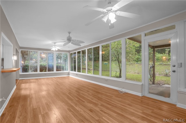 unfurnished sunroom featuring ceiling fan and plenty of natural light