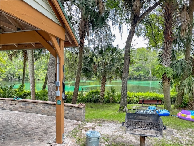 view of yard featuring a water view and a patio