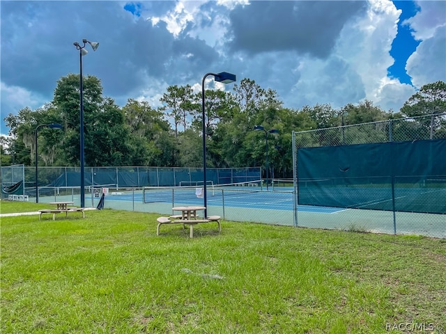 view of tennis court with a lawn