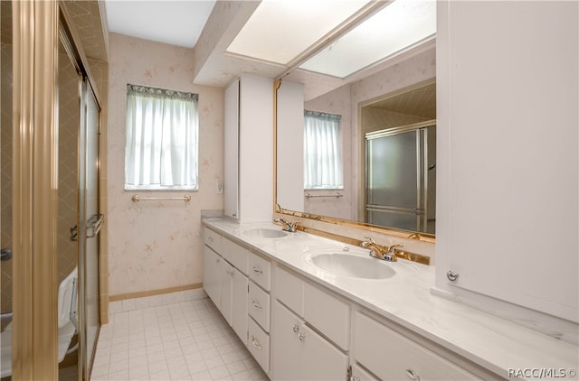 bathroom with tile patterned floors, a shower with door, and vanity