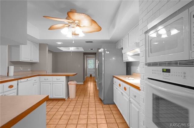 kitchen featuring white cabinets, light tile patterned floors, white appliances, and kitchen peninsula