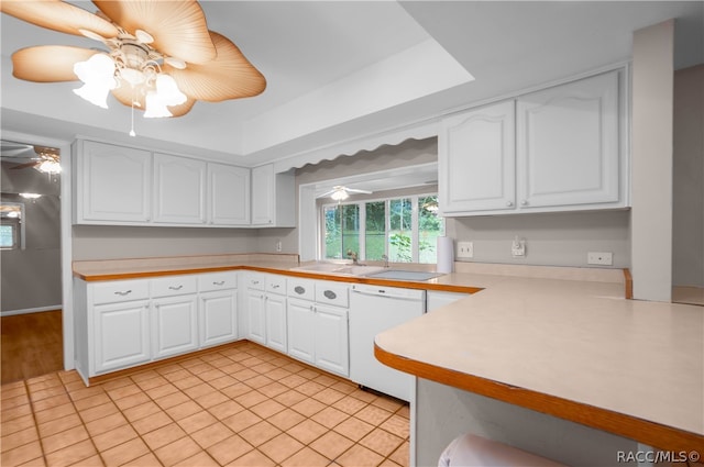 kitchen featuring dishwasher, white cabinets, sink, light tile patterned floors, and kitchen peninsula