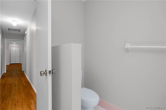 bathroom with hardwood / wood-style floors and toilet