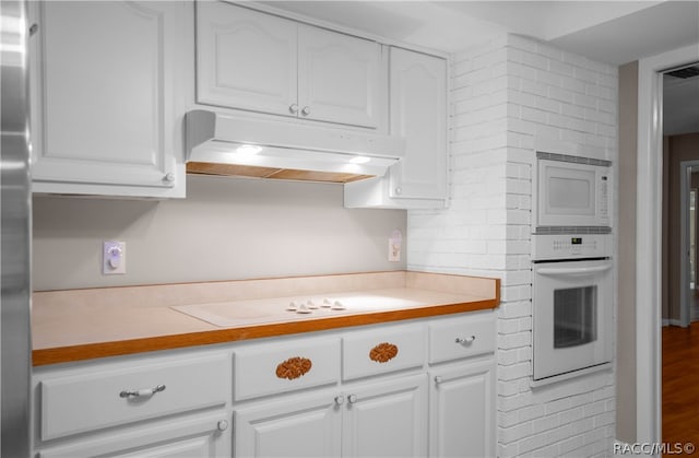 kitchen featuring white cabinets, white appliances, hardwood / wood-style flooring, and tasteful backsplash